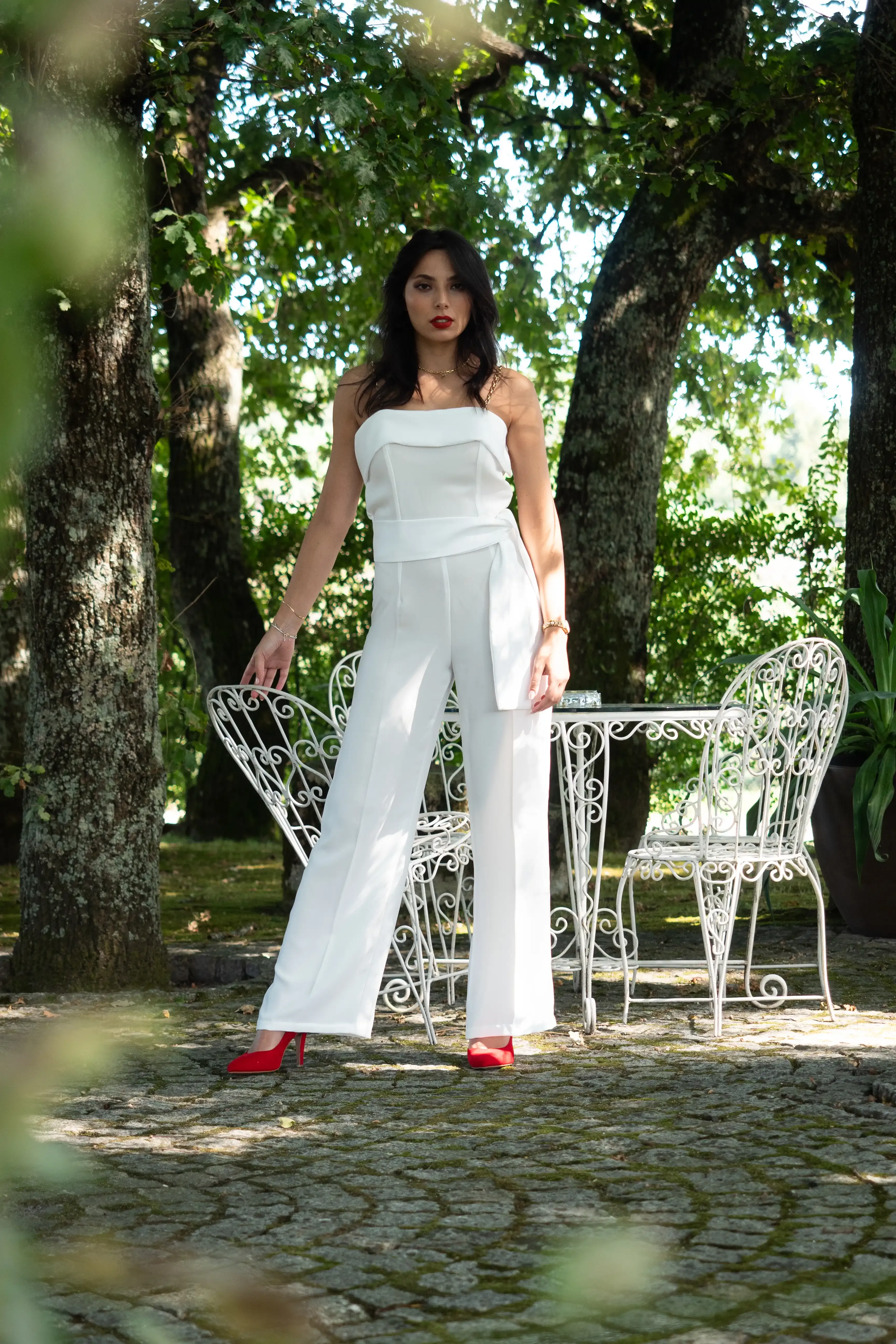 Uma mulher posa com um macacão branco elegante